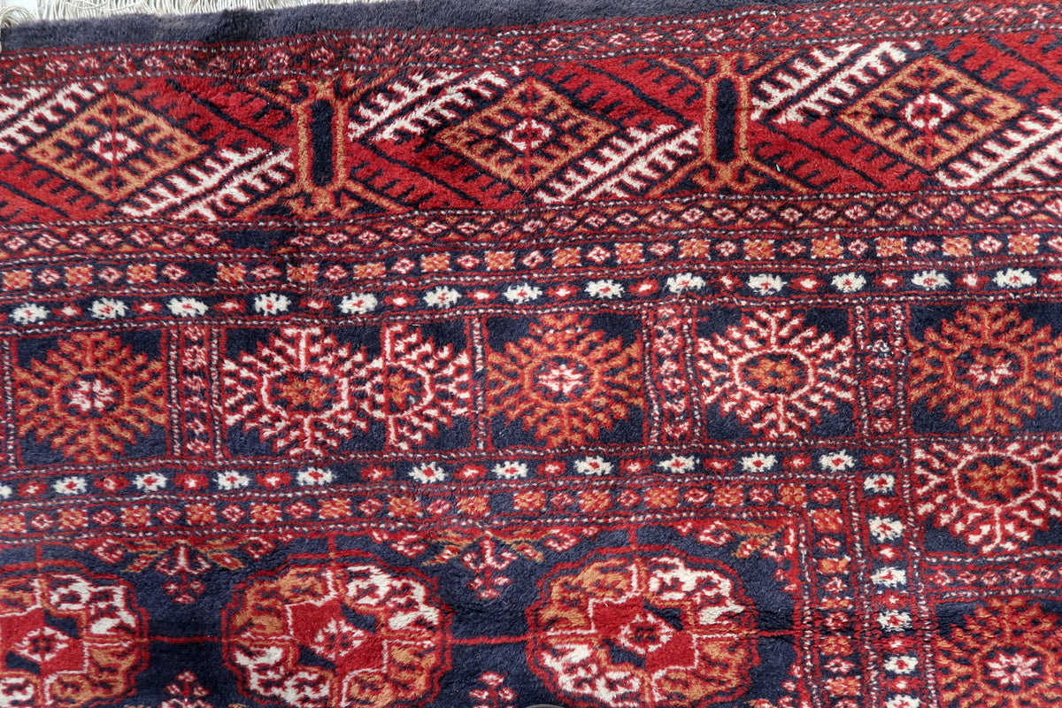 A detailed shot of the rug’s fringe, showing signs of vintage wear
