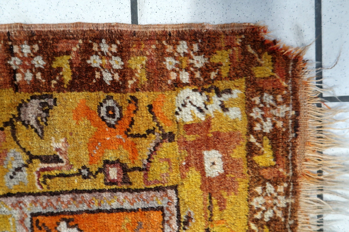 Antique Turkish wool rug laid flat, displaying its full pattern and coloration
