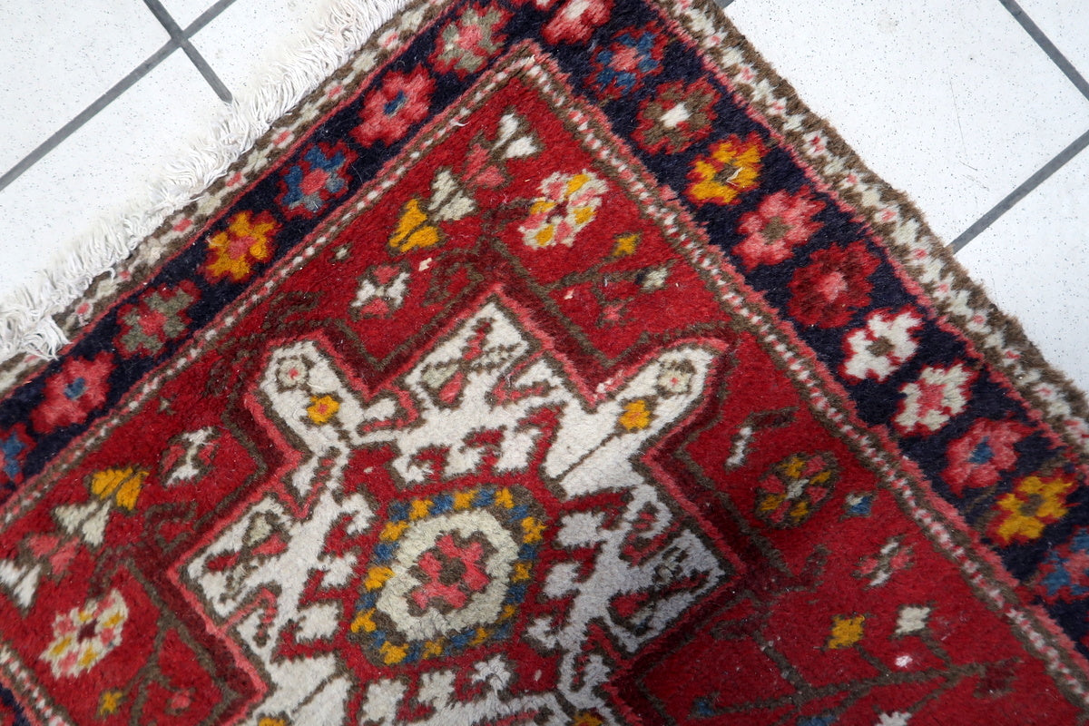 Full shot of the rug's vibrant red field, showcasing the multi-toned borders.
