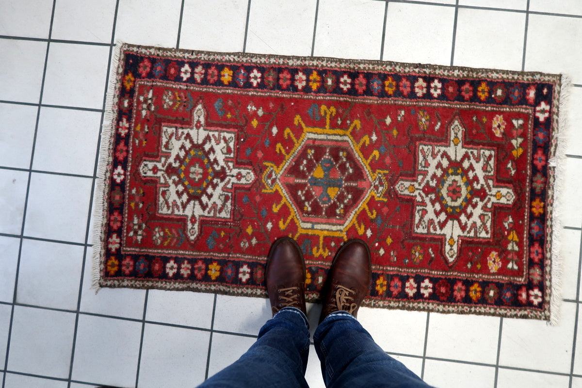 The rug displayed as a wall tapestry in a bohemian living room, demonstrating its versatility.
