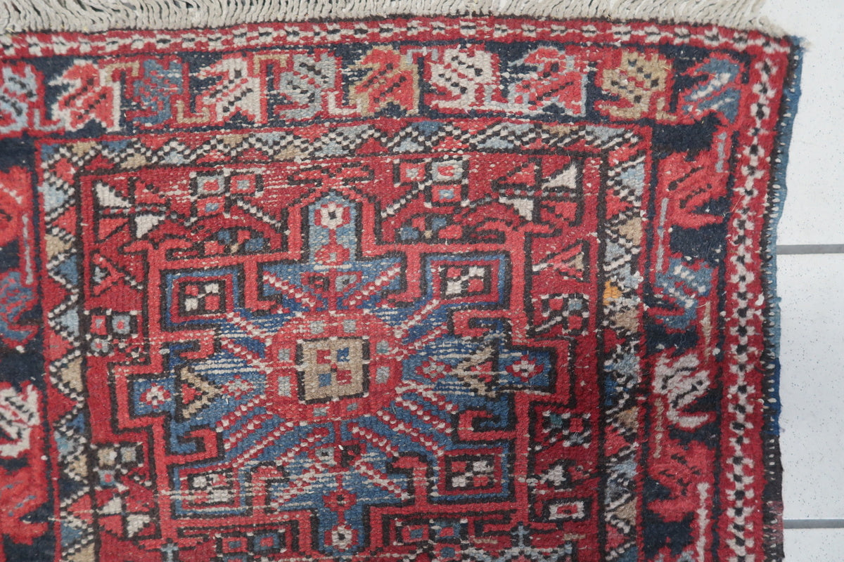 Close-up of the intricate floral and angular motifs in a vintage Karajeh rug
