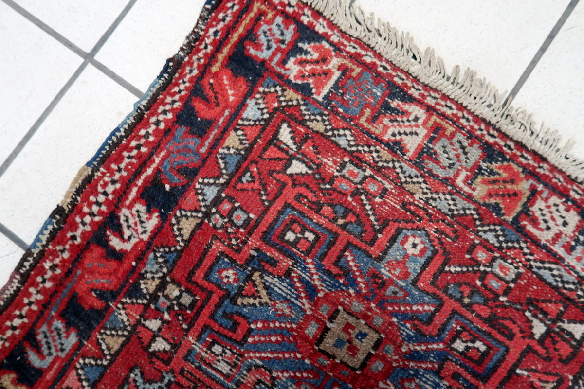 Handwoven Persian rug featuring deep reds, blues, and earth tones from vegetable dyes
