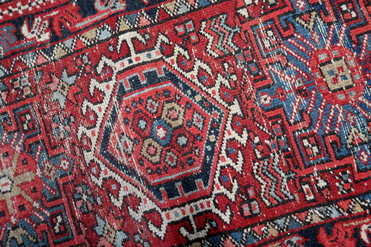 Geometric medallion patterns in an antique Persian rug with bold contrast
