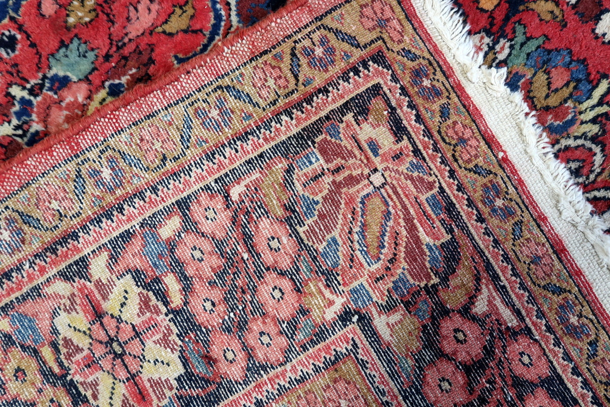 Detailed shot of the rug's traditional Mashhad weaving techniques
