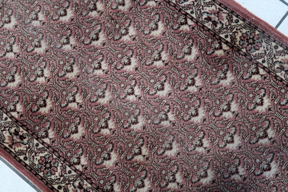 Close-up of the warm red and beige tones on a German Tabriz rug
