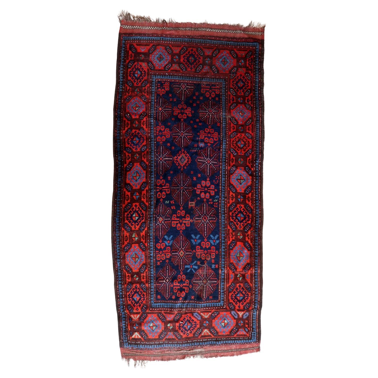 Handmade antique Afghan Baluch rug with deep blue and red tones
