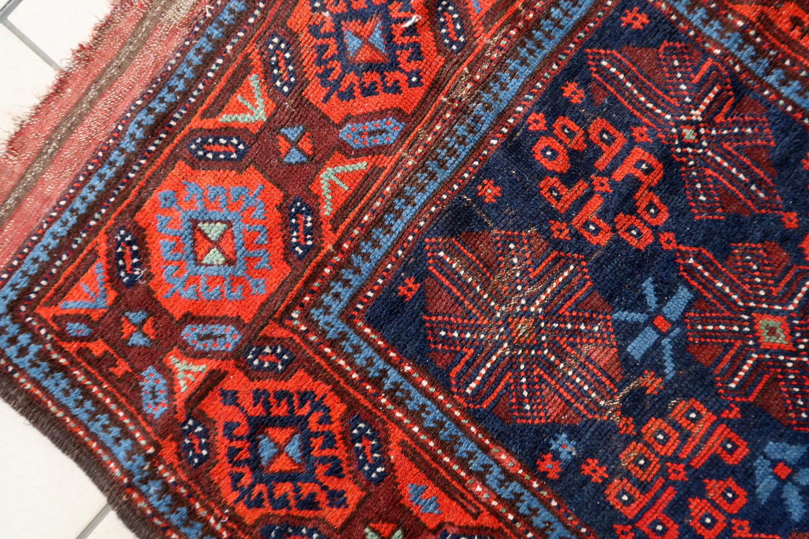 Detailed border patterns on an antique Persian tribal rug
