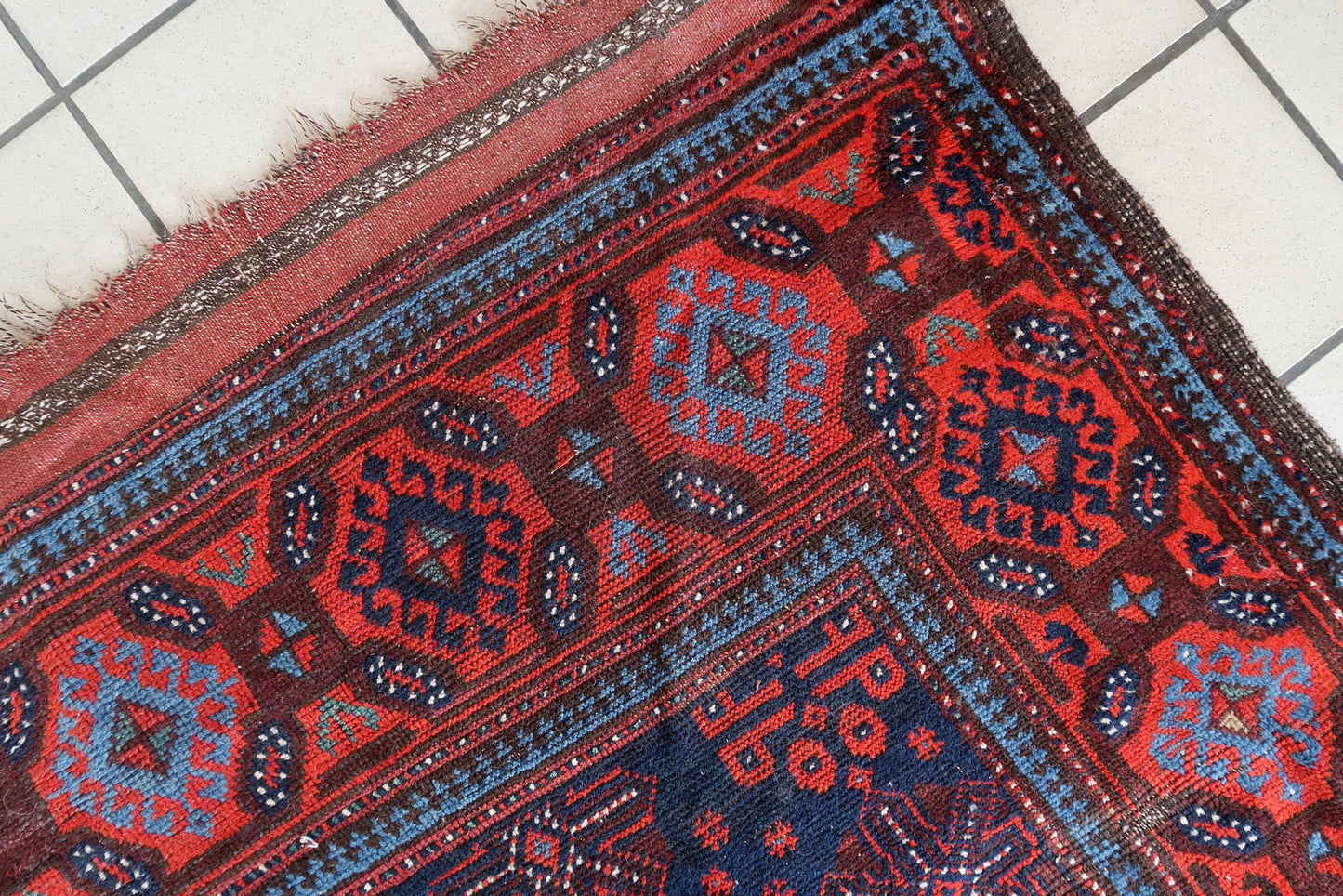 Hand-knotted Afghan Baluch rug with traditional tribal designs
