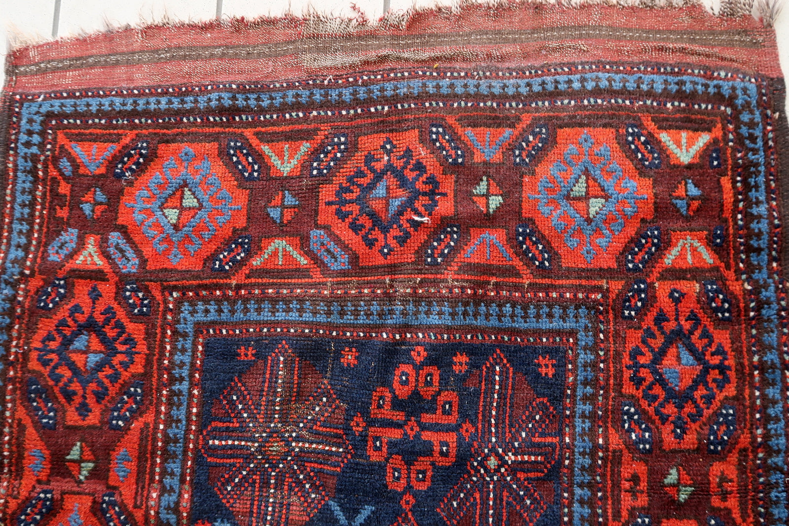 Tribal motifs on a handwoven Afghan Baluch wool carpet
