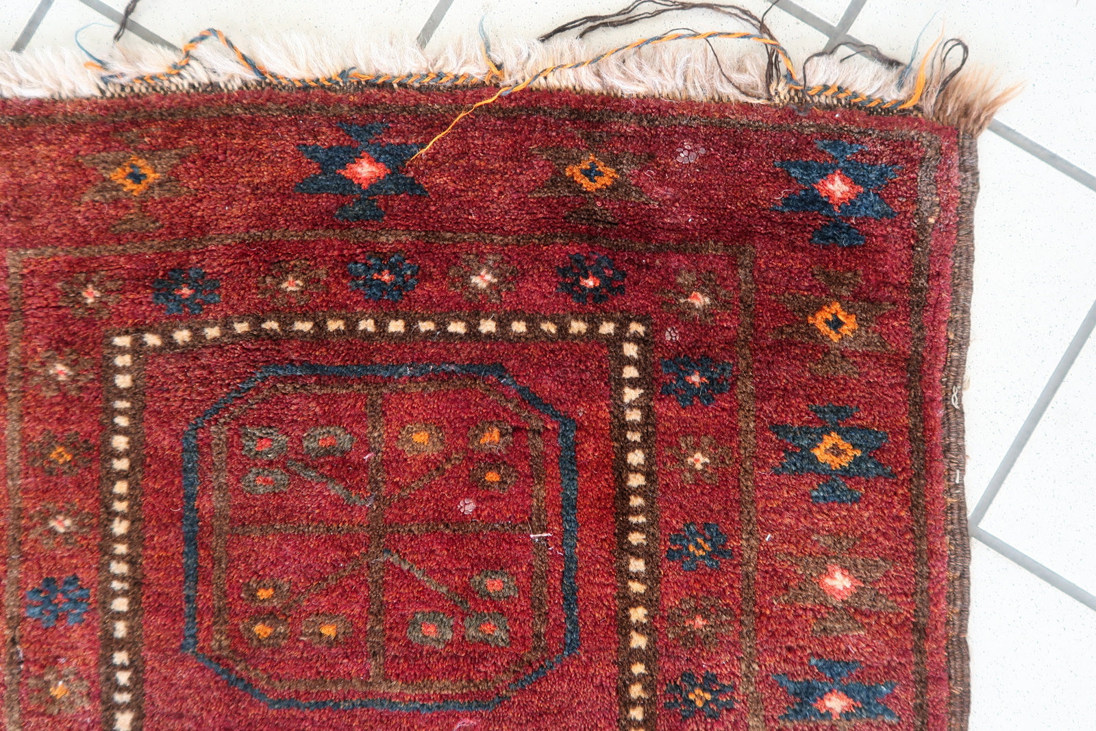 Close-up of geometric octagonal medallion patterns on a 1950s Afghan rug
