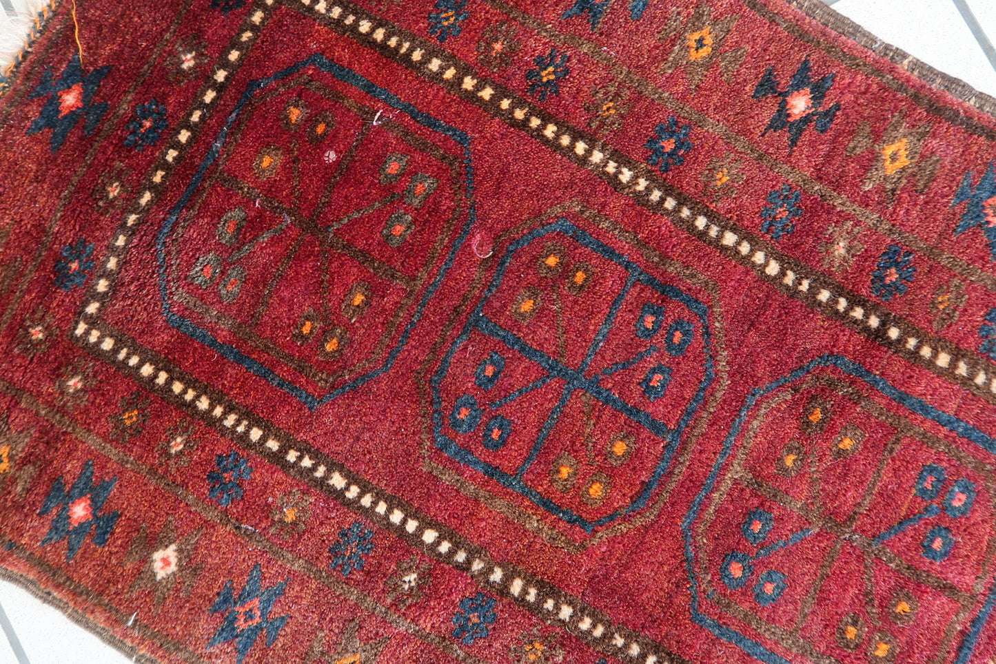 Full view of a small 2' x 3.5' vintage wool rug from Afghanistan
