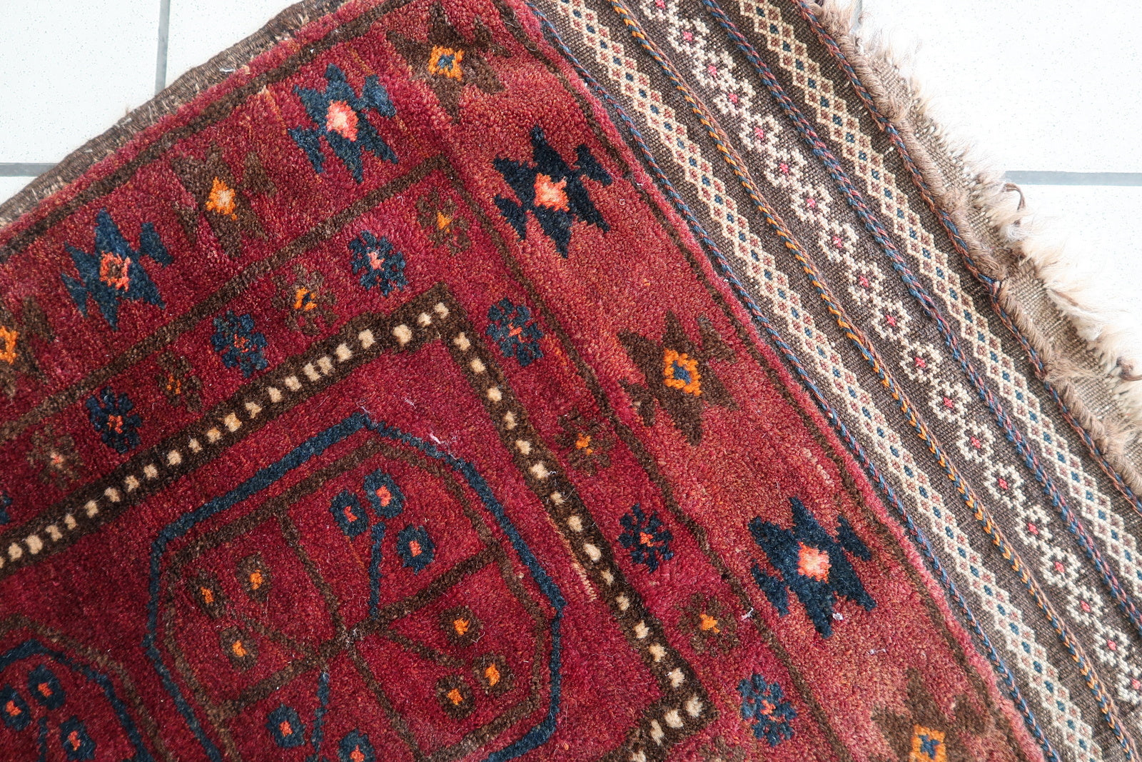 Fringe detail on a vintage Afghan Baluch rug, showing slight wear
