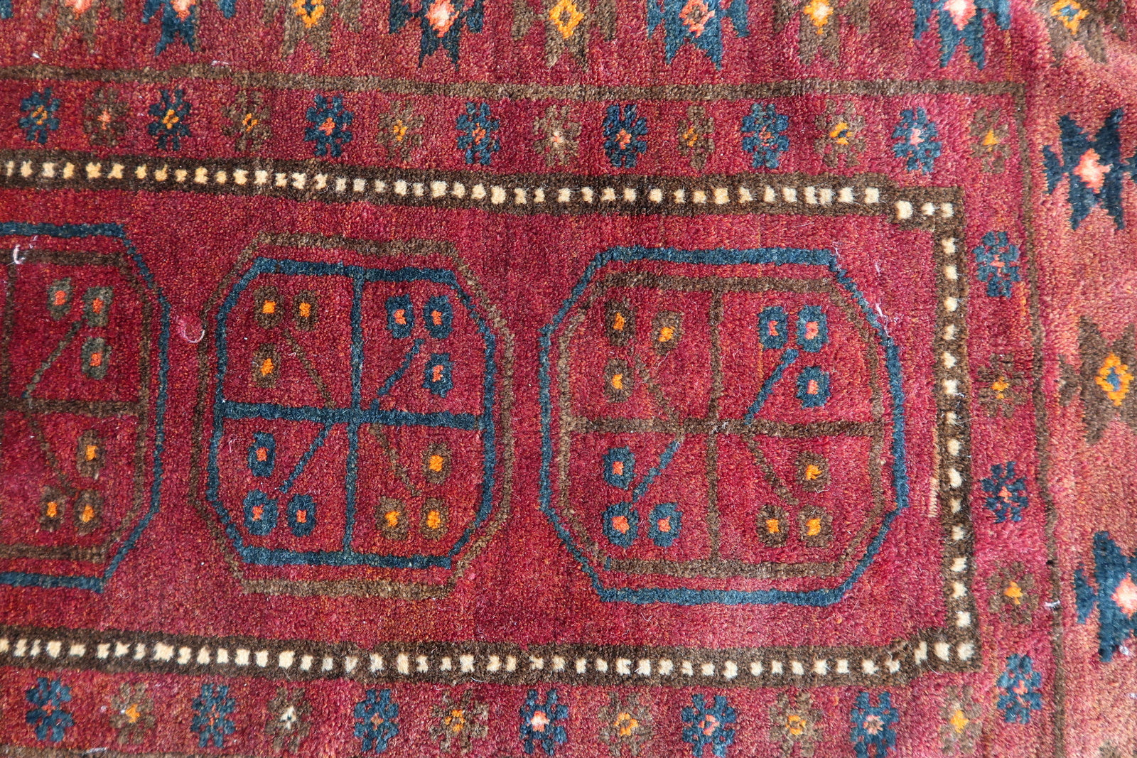 Detailed border patterns on a 1950s Baluch tribal rug
