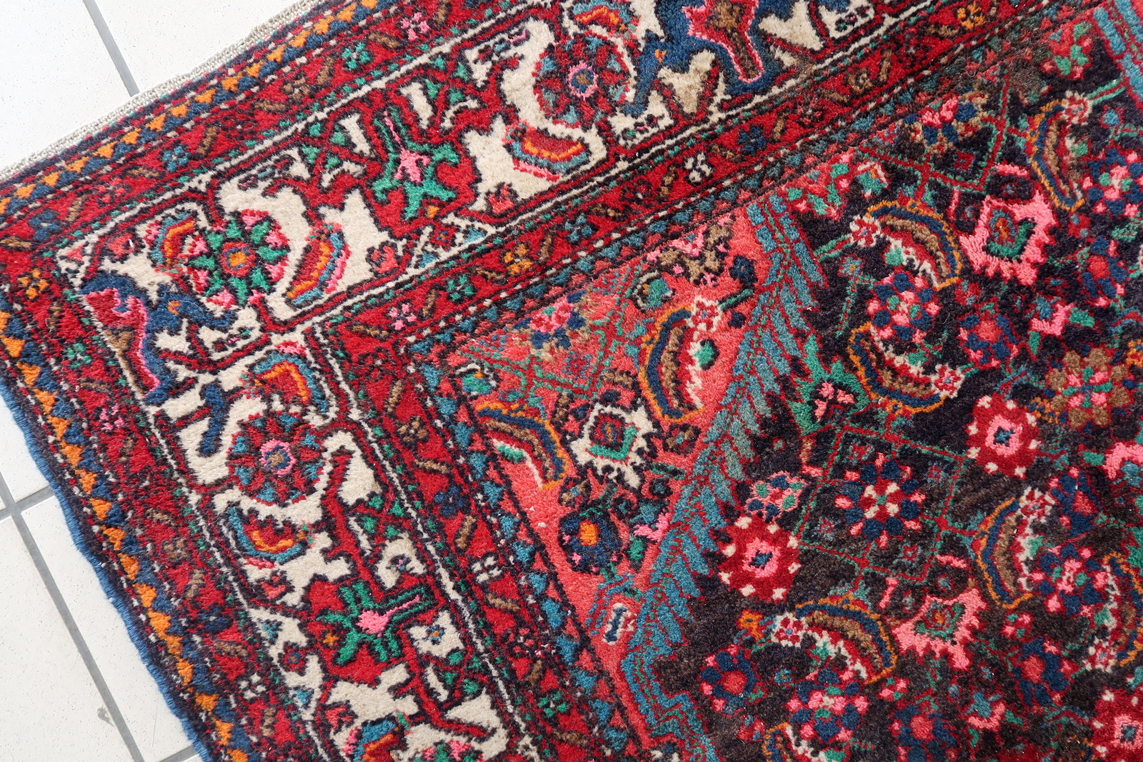 Vintage red and navy Persian rug with ivory accents
