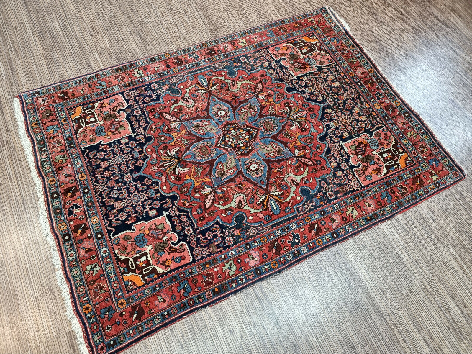 Antique Persian-style rug displayed in a living room setting
