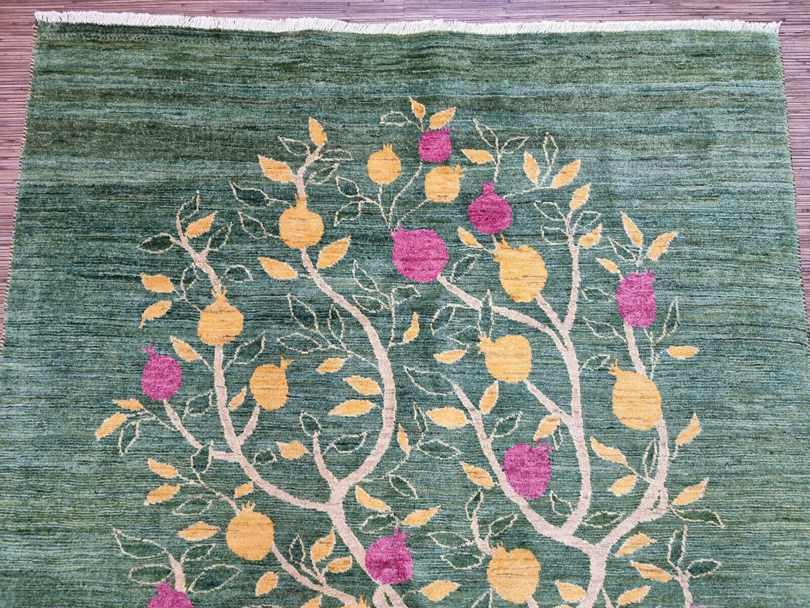 Close-up of the floral accents on the tree motif of the rug
