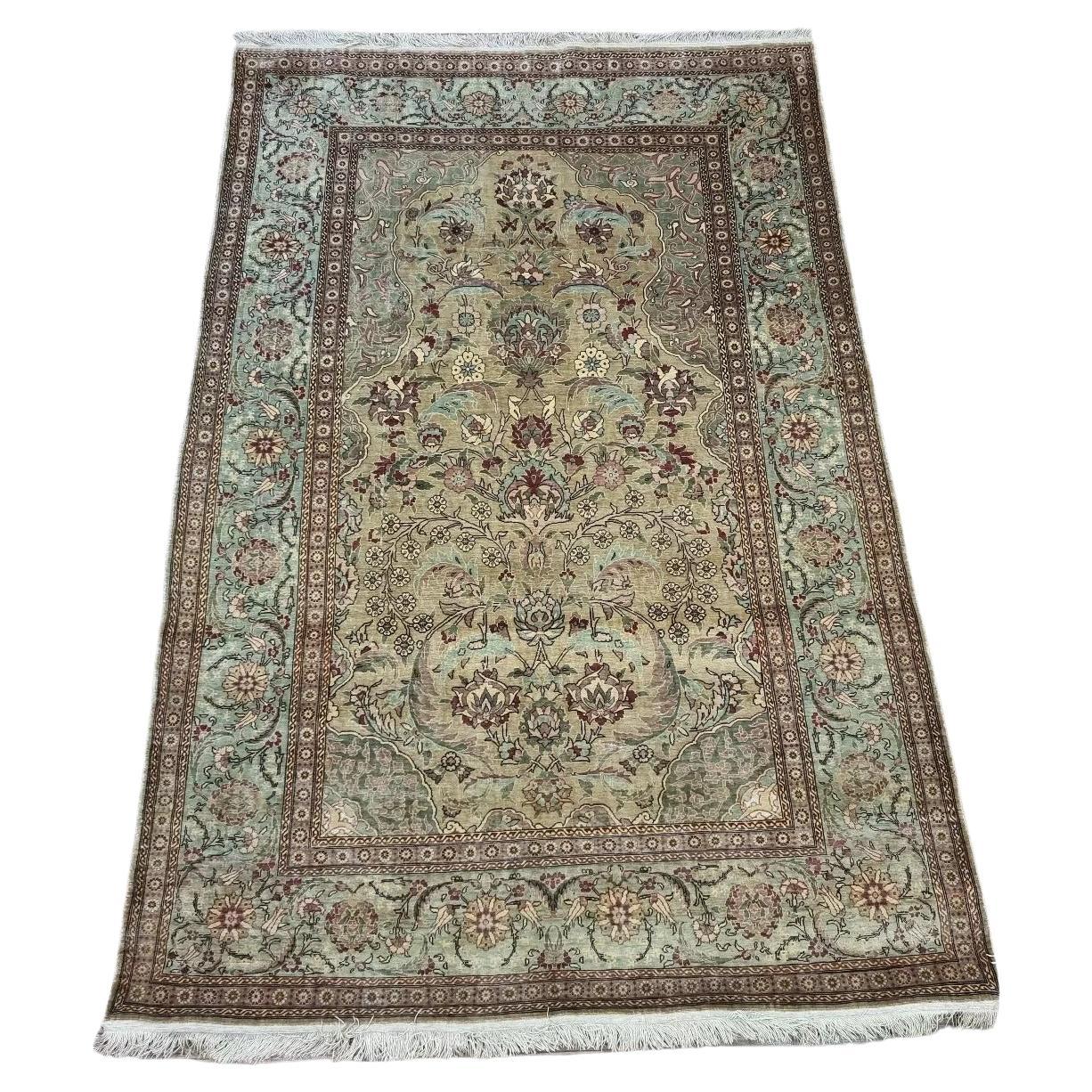 Vintage Turkish Hereke silk prayer rug with intricate floral patterns and a turquoise border
