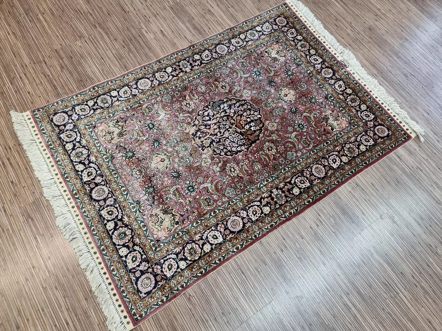 Close-up of the central floral medallion of the vintage silk rug.
