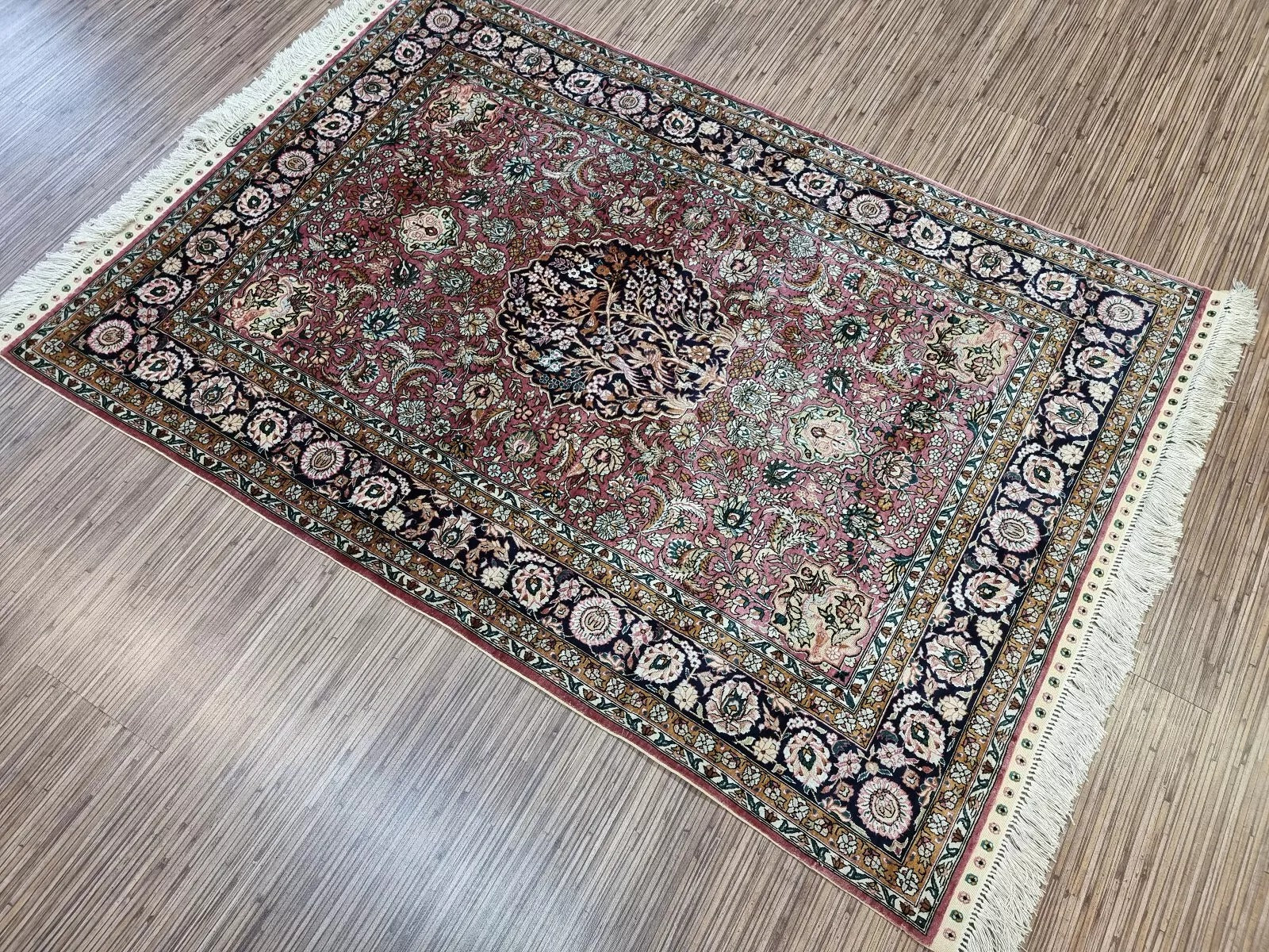 Detailed view of fringe on the edges of the Qum silk rug.
