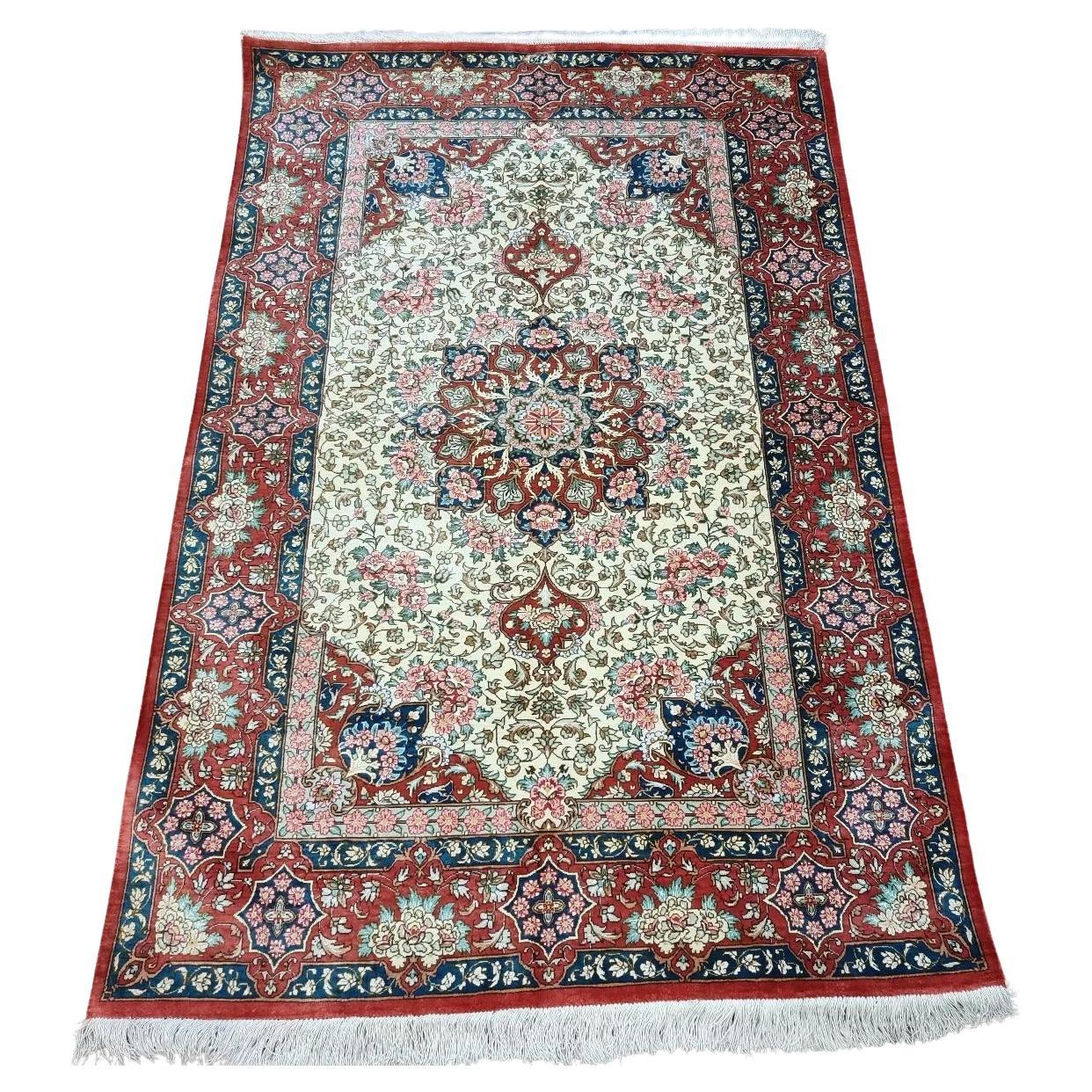 Handmade vintage Persian Qom silk rug with a floral medallion design.
