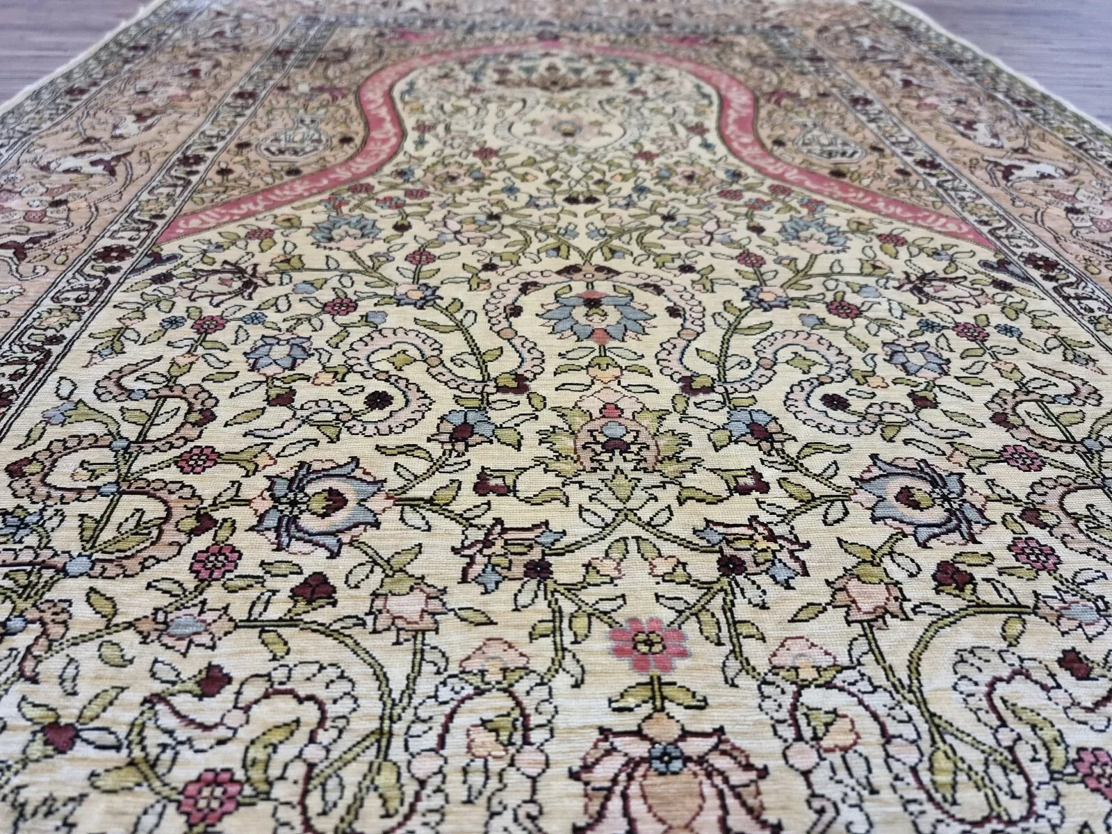 Close-up of prayer arch pattern on Hereke silk rug
