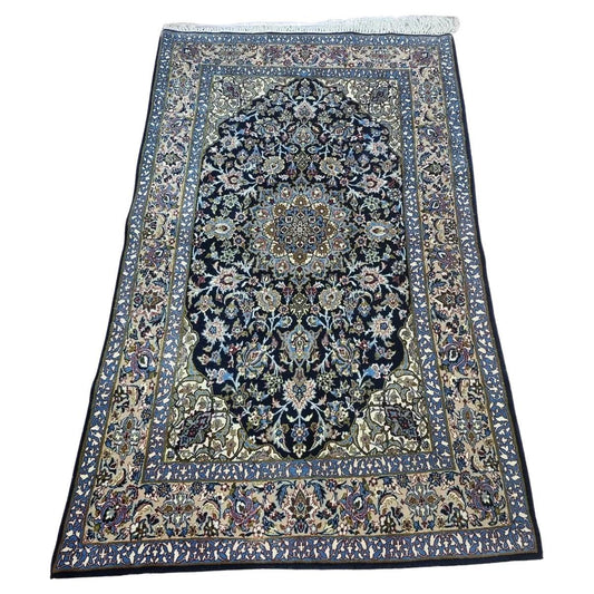 Handmade vintage Persian Isfahan rug with intricate floral motifs and a rich blue palette
