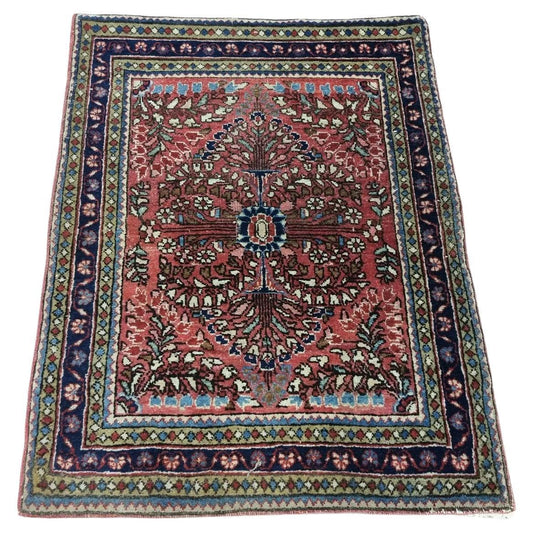 Handmade antique Persian-style Sarouk rug with vibrant red tones
