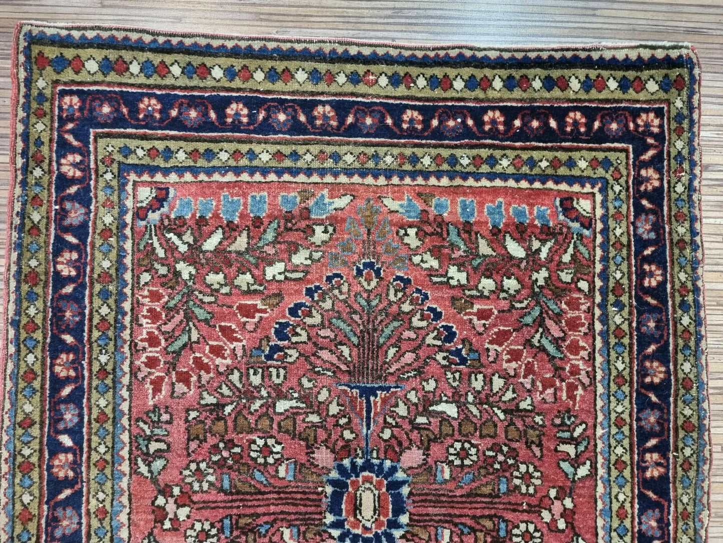 Antique Sarouk rug with deep red, blue, and ivory floral motifs
