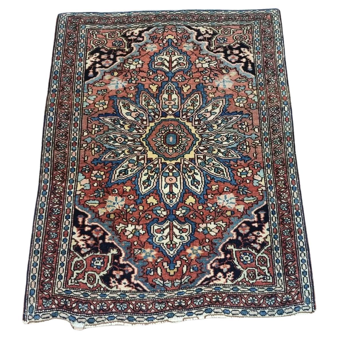 Handmade antique Persian Farahan rug with intricate brown and beige patterns
