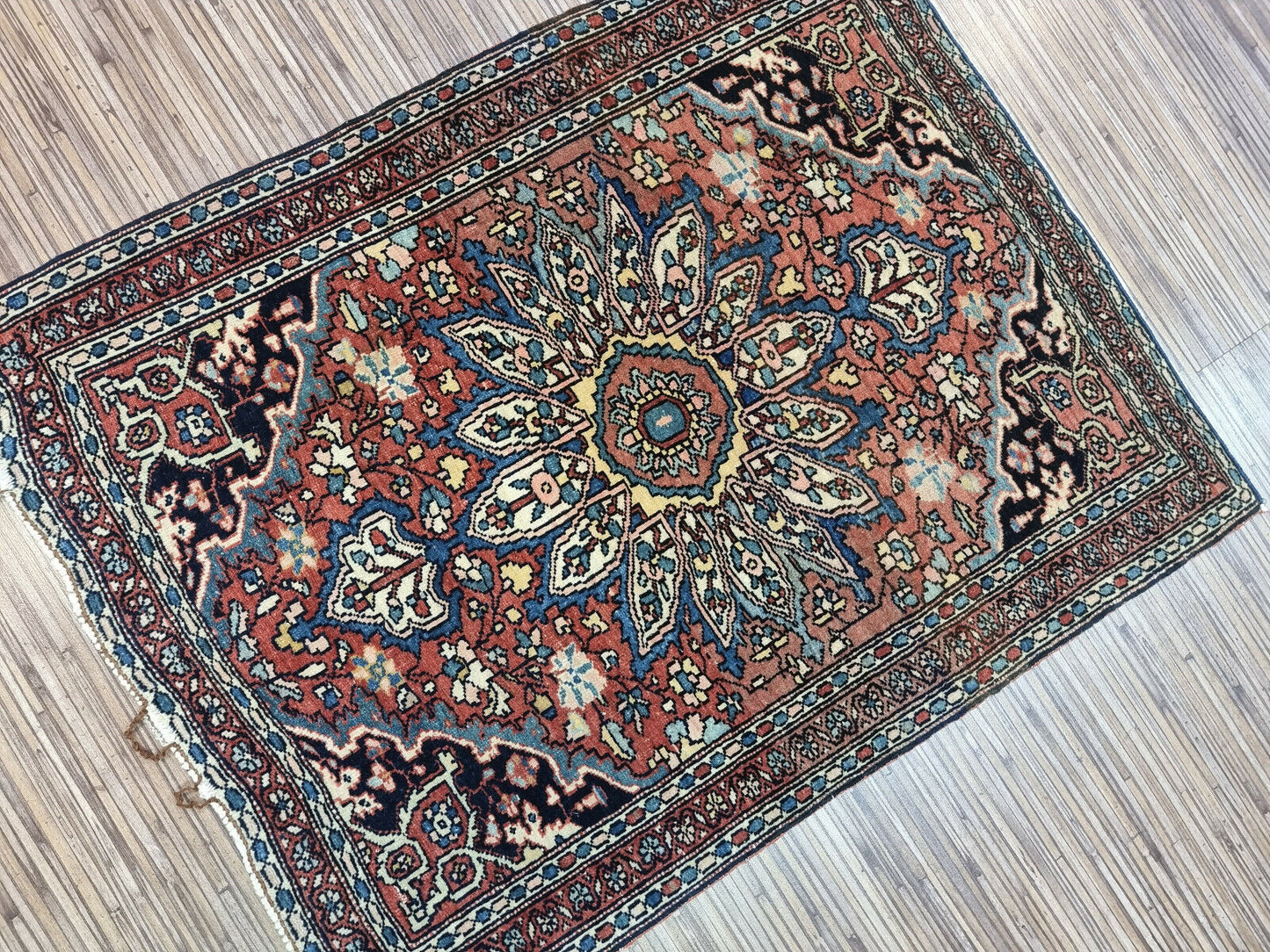 Antique Persian rug with a warm brown color palette and floral medallions
