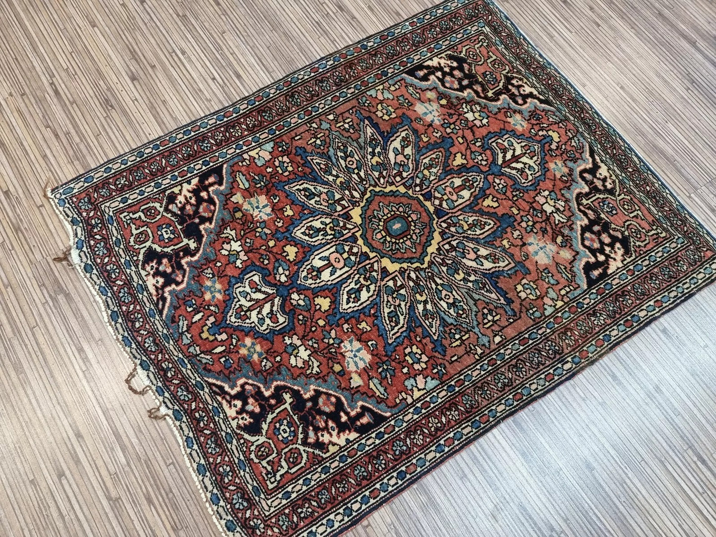 Handwoven Persian Farahan rug with deep earthy tones and elegant borders
