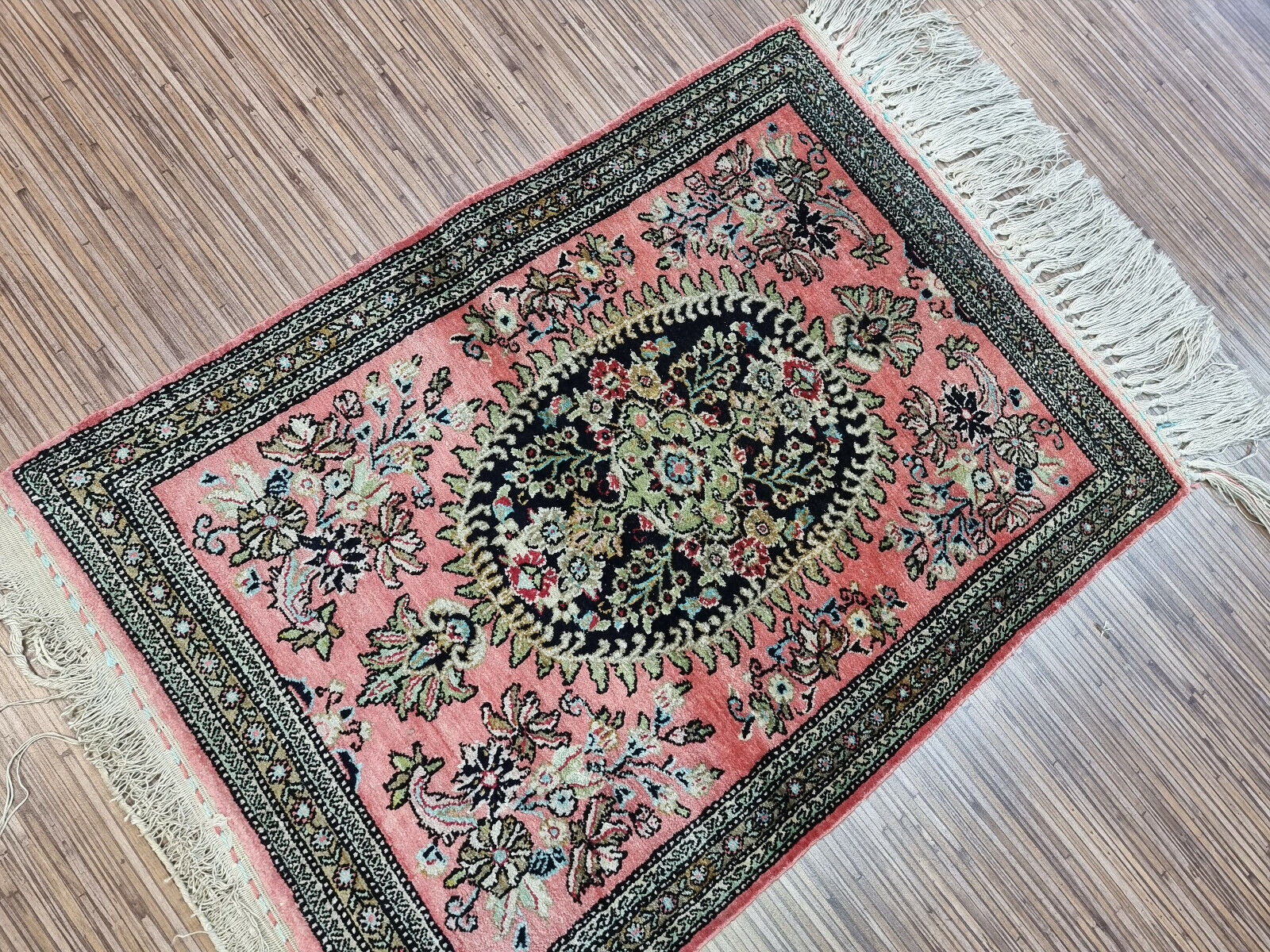 Full view of a small Persian Qum silk rug with elegant floral and geometric motifs
