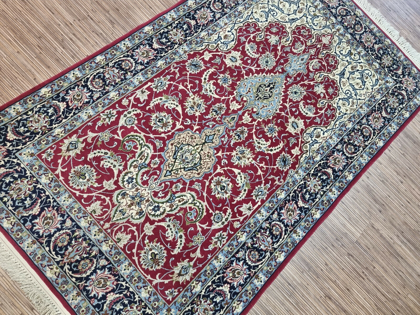 Full view of a Persian Isfahan prayer rug with deep red tones and detailed patterns
