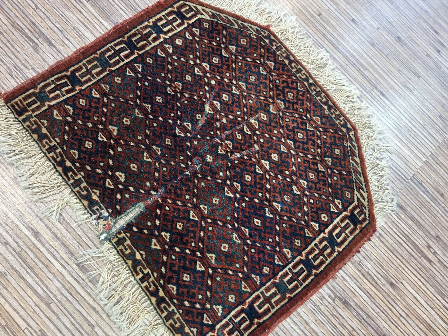 Antique Turkmen rug with rich red tones and intricate motifs
