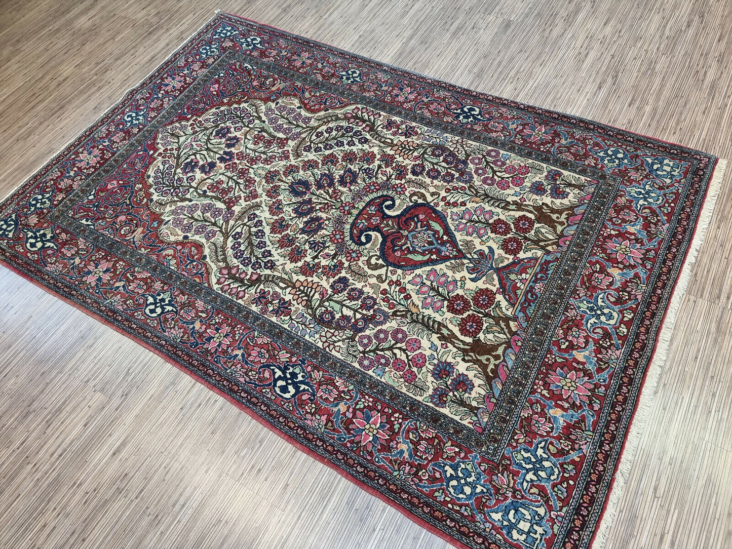 Vintage Wool Isfahan Prayer Rug (1900s): Close-up of the geometric patterns surrounding the central medallion, highlighting the rug's craftsmanship.