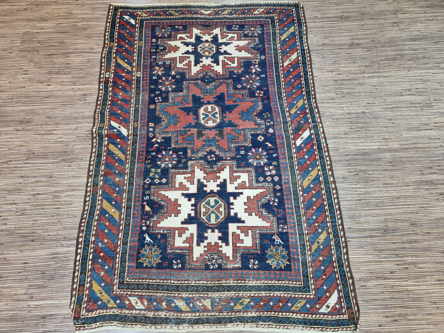 Ancient Tales Unraveled: Explore the intricate patterns and motifs that whisper stories of distant lands and cultures in this Antique Shirvan Rug.