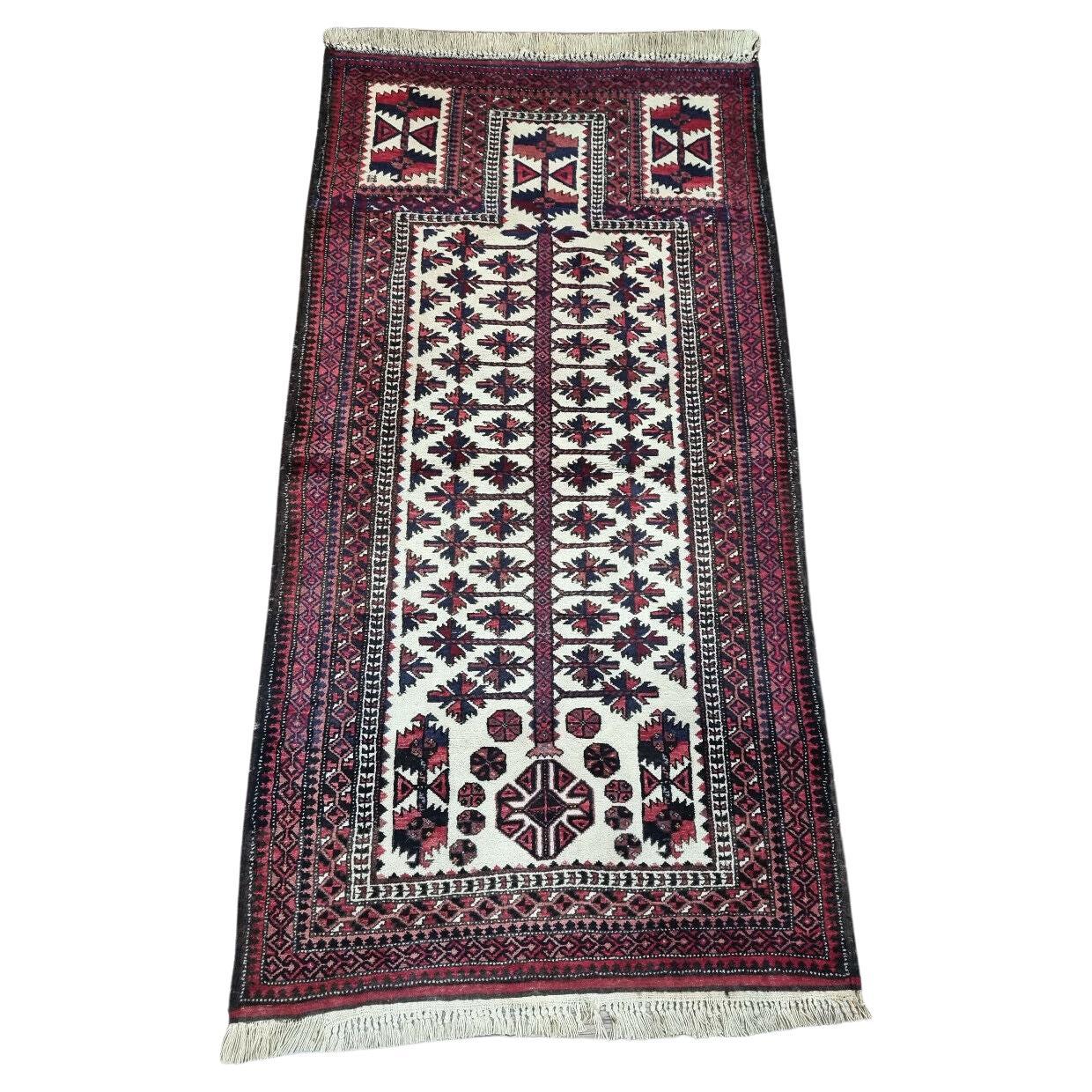 Handmade Afghan Beauty: Vintage Baluch Prayer Rug (1950s) with intricate geometric design (cream, red, blue).