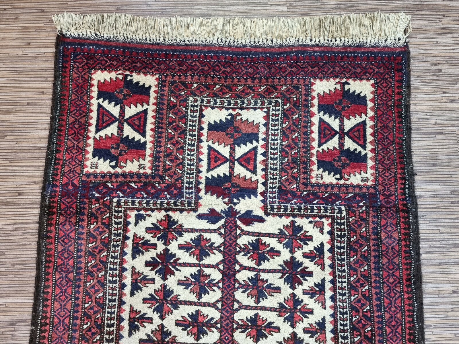 Bohemian Beauty: Handwoven Wool Rug (2.7' x 5.5') in Afghan Baluch style with geometric patterns (reds, blues).