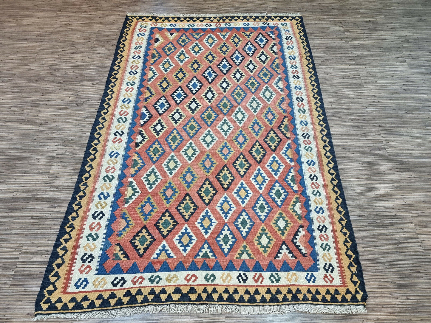 A Splash of Color: Vintage Persian Ardabil Kilim Rug (1970s) adds vibrancy to any space with its diamond pattern.