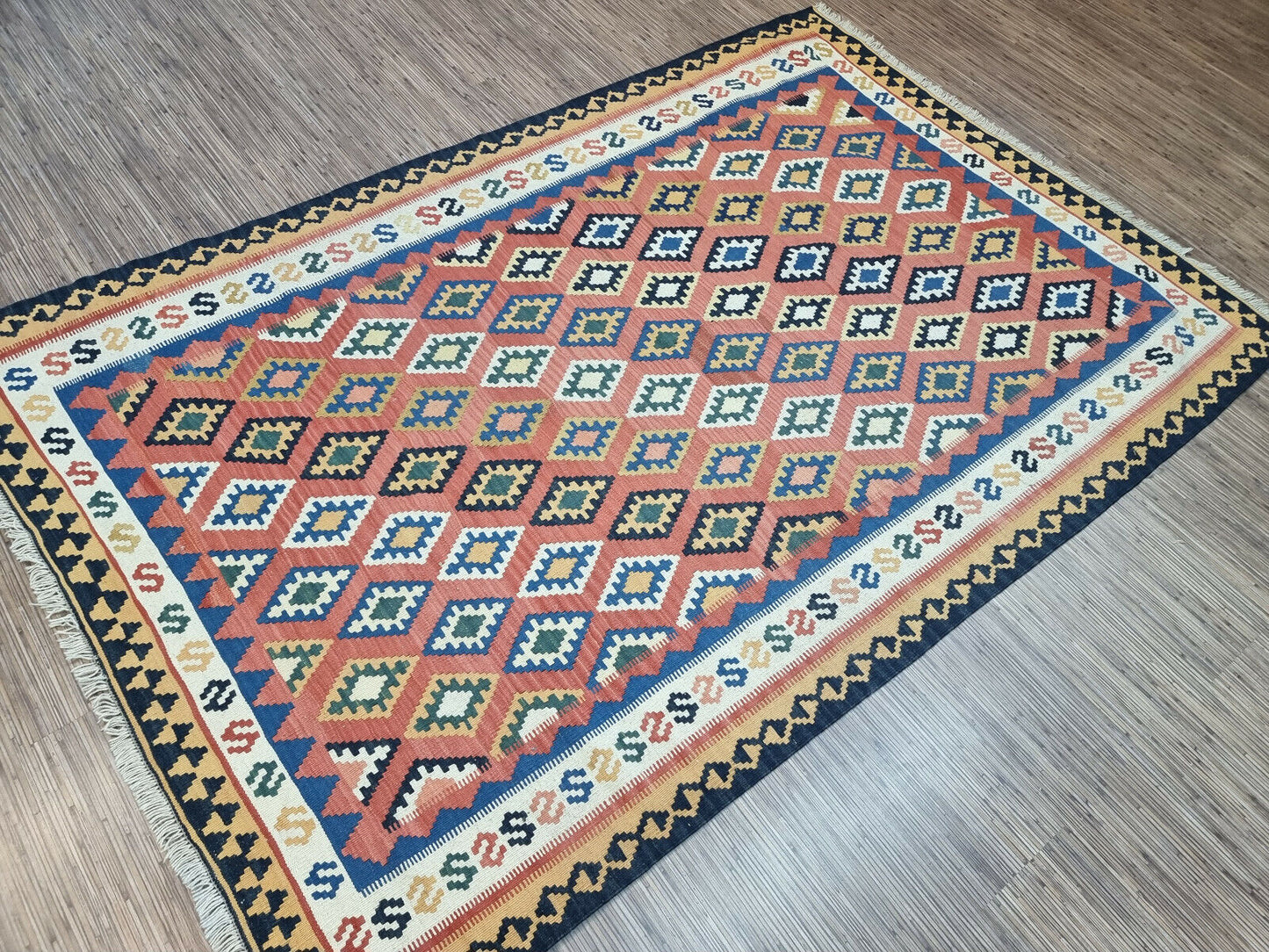 Geometric Harmony: Handwoven Wool Rug (Persian Ardabil Style) with a mesmerizing interplay of geometric shapes (reds, blues).