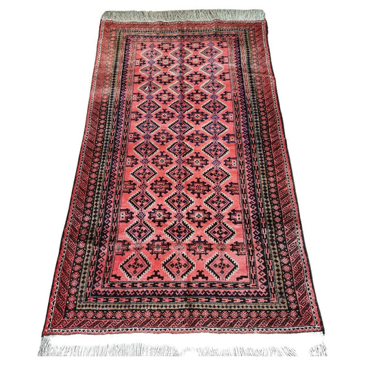 Handwoven Afghan Baluch Prayer Rug (1960s): Immerse yourself in the rich tapestry of Afghan craftsmanship with this vintage prayer rug, featuring intricate geometric patterns and symbolic motifs.