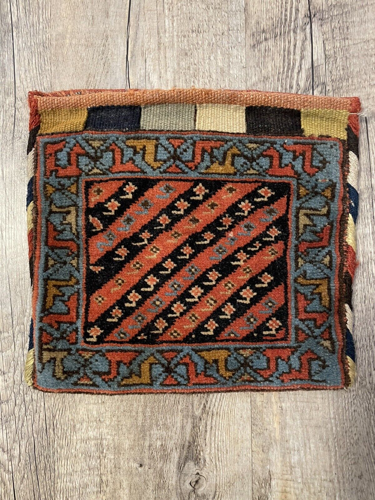 A close-up of the high-quality natural wool used in the handmade antique Persian Gashkai small bag (1900s), highlighting the rich texture and organic dyes.