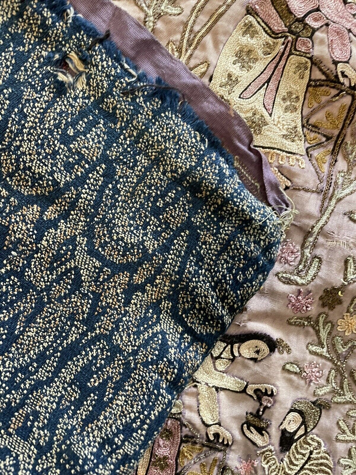 The back of a hand-embroidered Chinese silk artwork (1880s), revealing the intricate web of silk threads in a natural color. The visible knots demonstrate the meticulous hand-stitching technique employed.