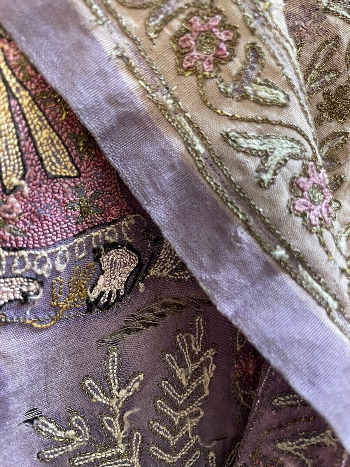 A close-up of the embroidery stitches, revealing the different techniques used to create various textures and shapes within the artwork.