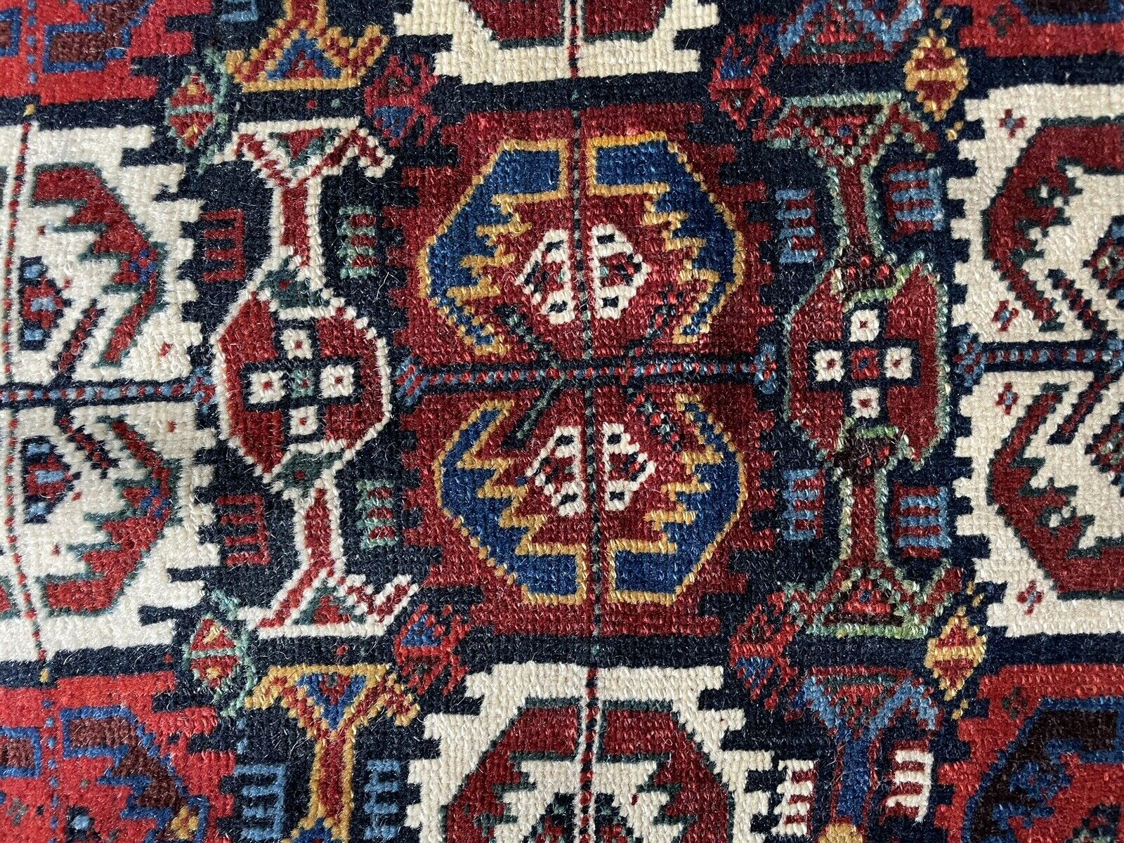 Detailed Central Medallion: A close-up of the central medallion on the Gashgai bagface (1880s), highlighting the use of various colored wools and intricate knotting techniques to create a captivating design.