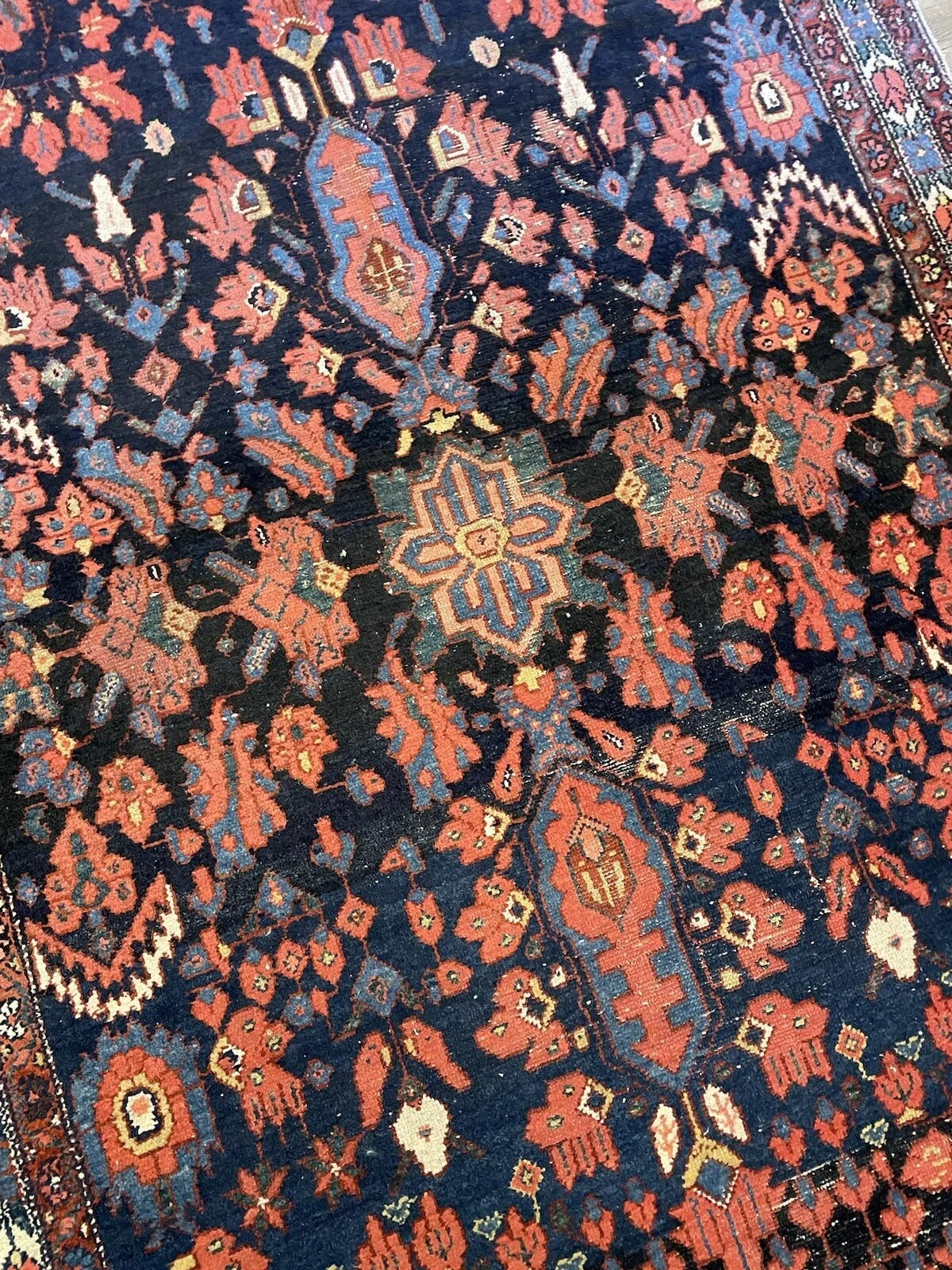 Traditional handmade Bakhtiari rug in dark blue, red, white, and orange hues
