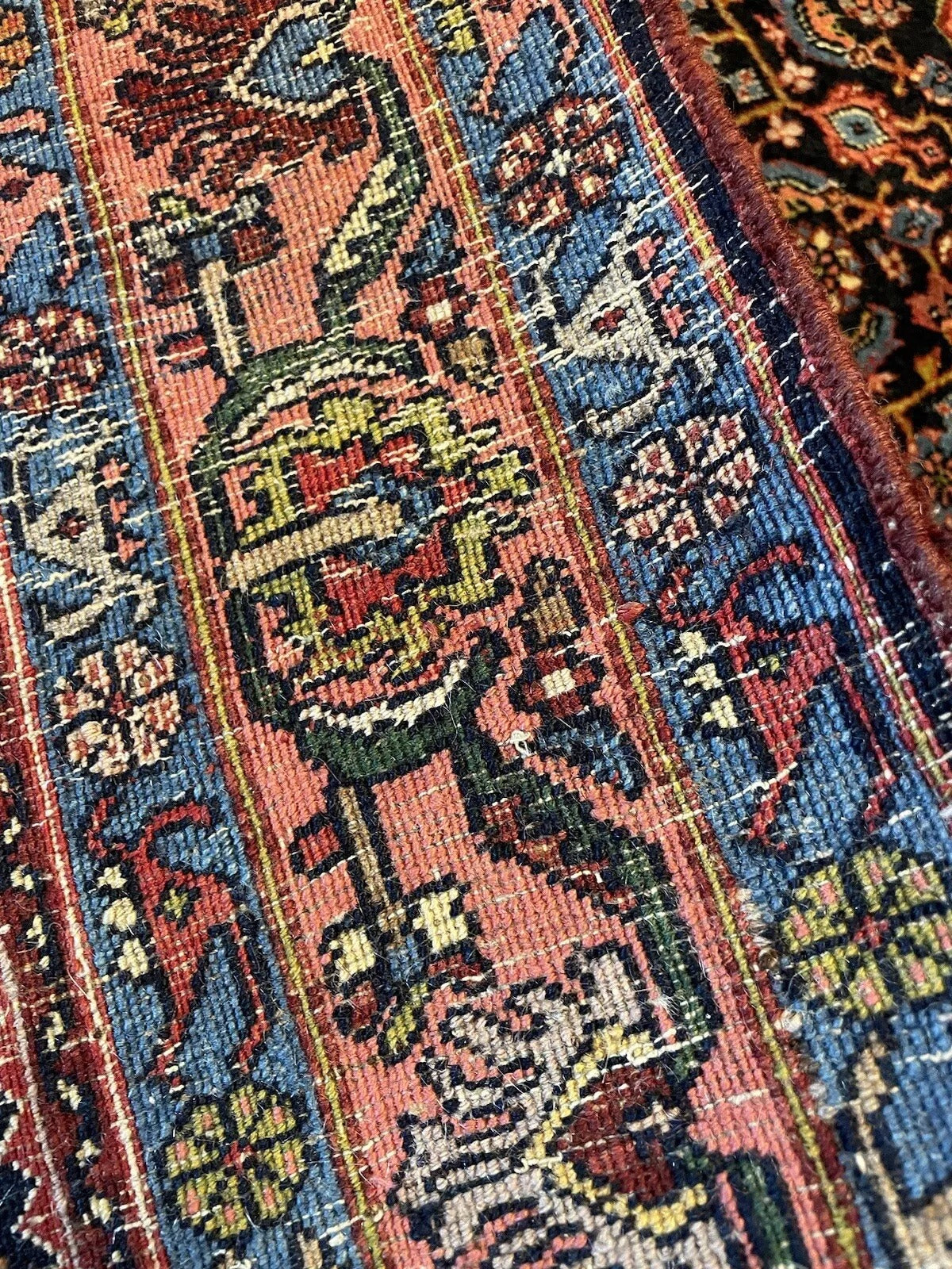 Deep red, navy blue, and beige color palette on antique Bidjar carpet
