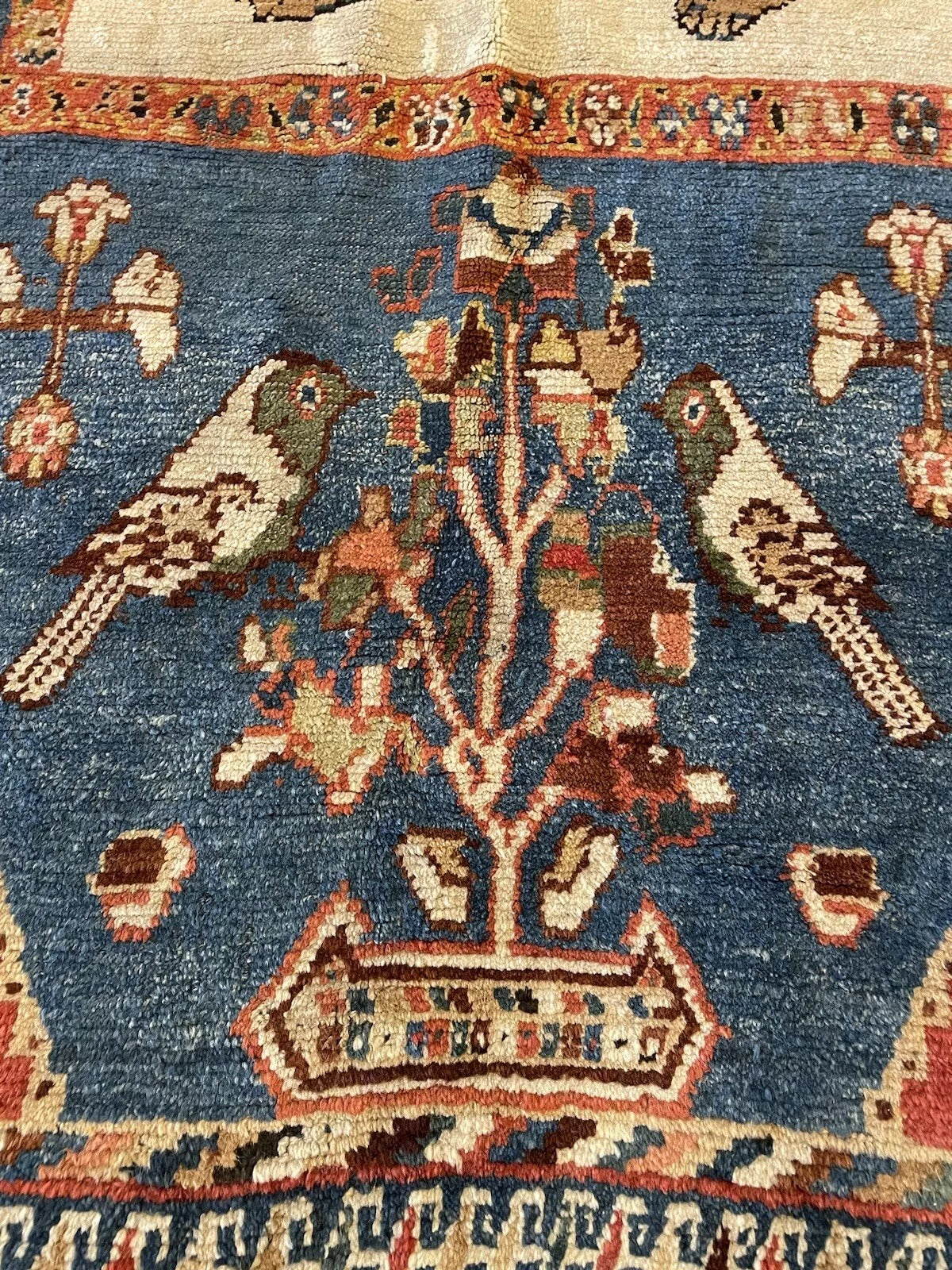 Traditional handmade Middle Eastern rug with lion and bird motifs
