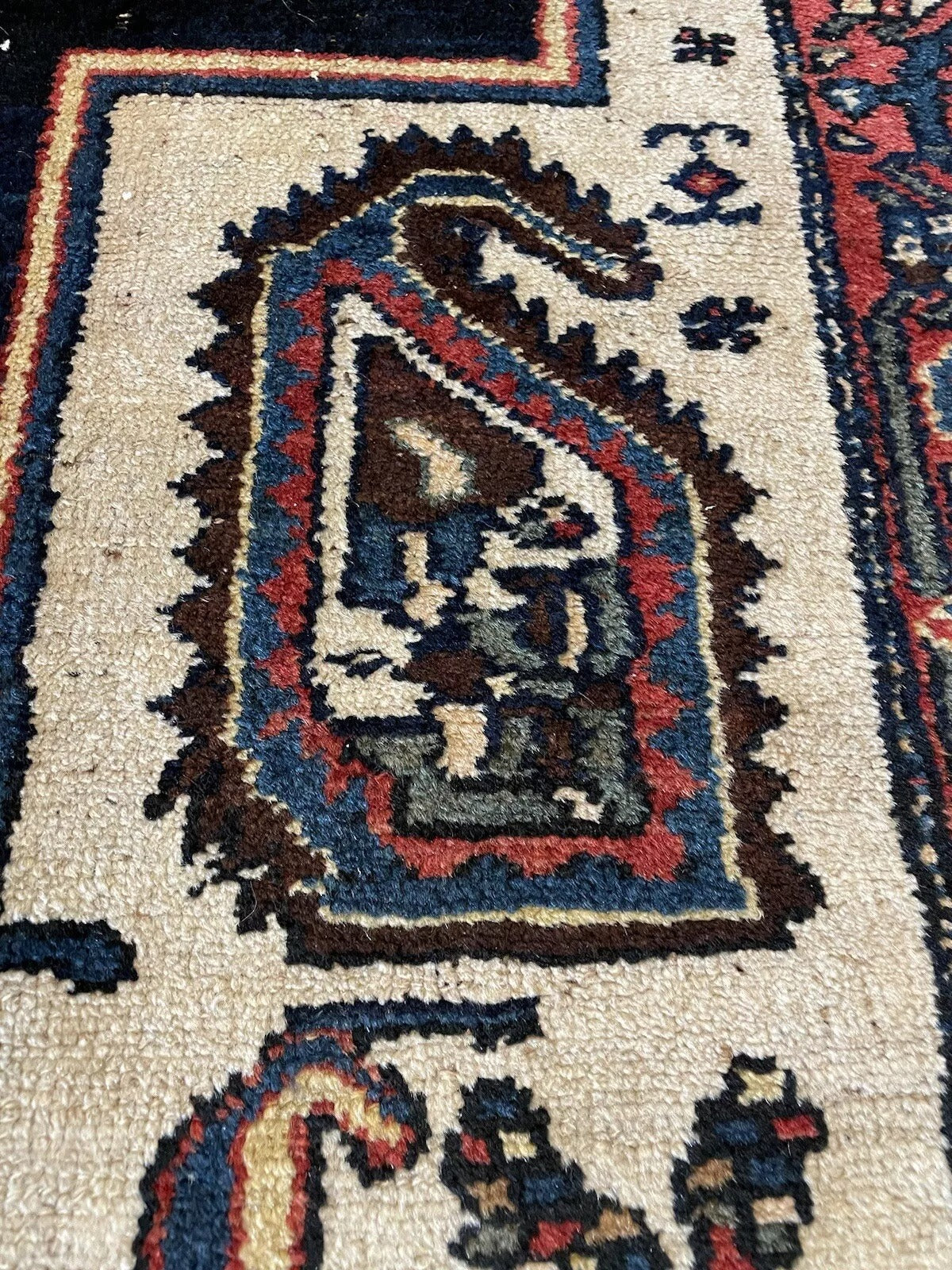 Close-up of intricate geometric motifs on an antique wool rug
