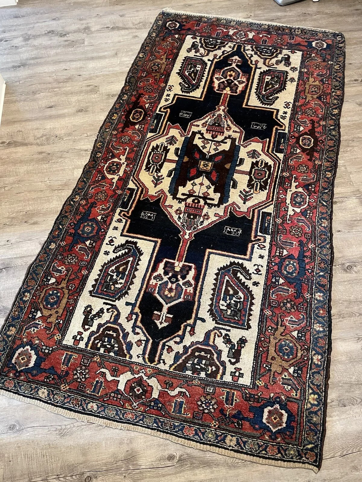 Intricately designed antique wool rug with floral details
